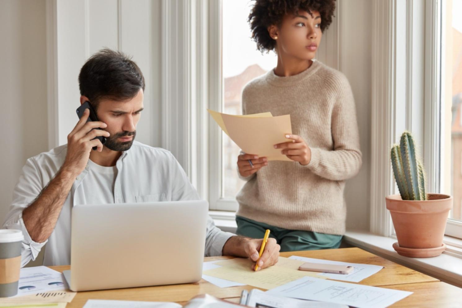 Personne travaillant sur un plan budgétaire avec calculatrice et documents